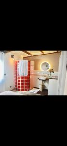 a bathroom with a sink and a red and white shower at Villa with pool close to the sea in Saint-Gilles les Bains