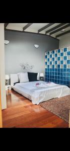 a bedroom with a large white bed with blue tiles at Villa with pool close to the sea in Saint-Gilles les Bains