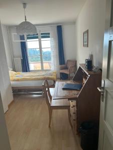 a bedroom with a desk and a bed and a desk with a laptop at Hotel Haltenegg in Heiligenschwendi