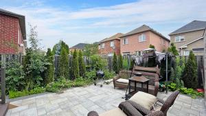 a patio with two chairs and a grill in a backyard at Stunning 2BR Lower Level Unit in Vaughan