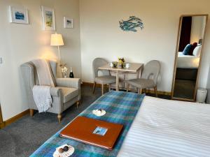Habitación de hotel con cama, mesa y sillas en SEAcroft Licensed B&B and Restaurant en Aird Uig