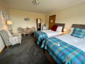 a hotel room with two beds and a table at SEAcroft Licensed B&B and Restaurant in Aird Uig