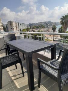 een tafel en stoelen op een balkon met uitzicht op het strand bij ÖZTUR OTEL YUMURTALIK in Yumurtalık