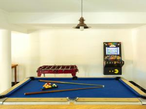una mesa de billar en una habitación con un videojuego en Hotel San Carlos en San Antonio de Areco