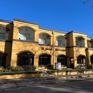 ein gelbes Gebäude mit einem Hotel an der Seite in der Unterkunft Hotel San Carlos in San Antonio de Areco