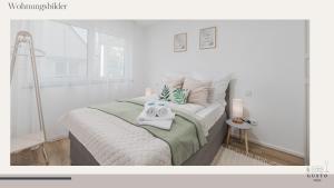 a white bedroom with two towels on a bed at Design-Apartment - Gusto stays! in Remseck am Neckar