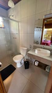 a bathroom with a toilet and a sink and a shower at Pedacinho de Chão Chalés in Visconde De Maua