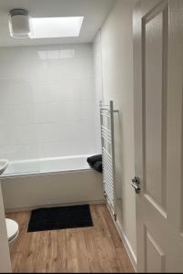 un bagno con vasca, servizi igienici e porta di The Coach House a Welwyn Garden City