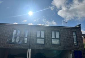 un edificio di mattoni con il sole nel cielo di The Coach House a Welwyn Garden City