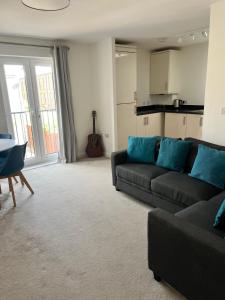 a living room with a couch and a kitchen at The Coach House in Welwyn Garden City