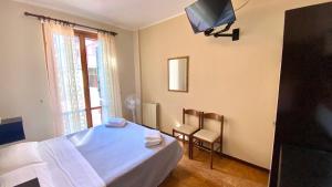um quarto com uma cama, uma televisão e uma janela em Umbria Green Central Rooms em Castiglione del Lago