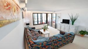 a living room with a couch and a tv at Apartamento, Arena, Primera linea Mar, sea views in Playa Honda