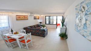 a living room with a couch and a table and chairs at Apartamento, Arena, Primera linea Mar, sea views in Playa Honda