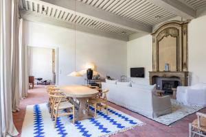 a living room with a table and a couch at Maison Salix in Vallabrègues