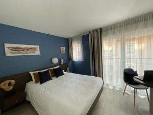 托農萊班的住宿－巴拉丁斯公寓酒店，一间卧室设有一张大床和蓝色的墙壁