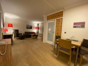 ein Wohnzimmer mit einem Sofa, einem Tisch und Stühlen in der Unterkunft Hotel Sonnenhügel in Bad Bevensen