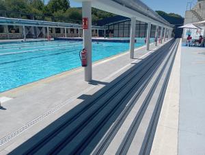 uma piscina com um parquímetro vermelho ao lado em Súper apartamento Santiago em Santiago de Compostela