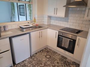 a kitchen with white cabinets and a sink and a stove at Beautiful 3-Bed House in Ramsgate in Ramsgate