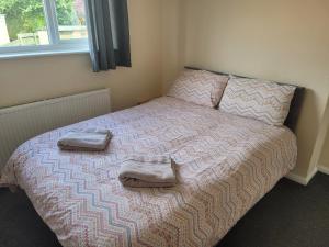 a bedroom with a bed with two towels on it at Beautiful 3-Bed House in Ramsgate in Ramsgate