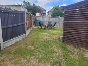 a patio with chairs and a table in a yard at Beautiful 3-Bed House in Ramsgate in Ramsgate