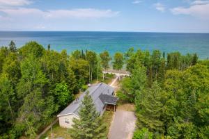 Una vista aérea de una casa en el bosque junto al océano. en Cheboygan Getaway with Fire Pit and Lake Access!, en High Banks