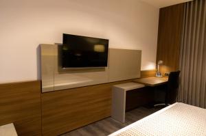 フォス・ド・イグアスにあるJL Hotel by Bourbonのホテルルーム(壁に薄型テレビ付)