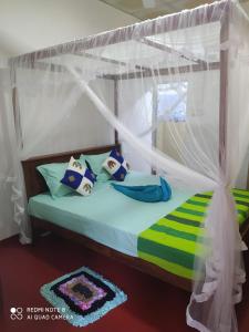 a bedroom with a bed with a canopy at Rosy guest house. in Mirissa