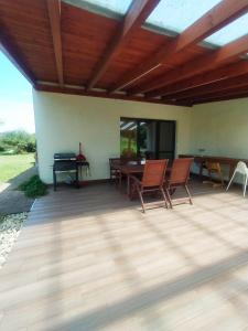a patio with a wooden roof with chairs and a table at Bíbor-lak ökoszálláshely in Pannonhalma