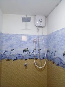 a shower in a bathroom with a mural of dolphins at Rosy guest house. in Mirissa +51 photos
