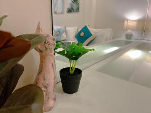 a statue of a cat next to a potted plant at Pure Stay At CNX in Chiang Mai