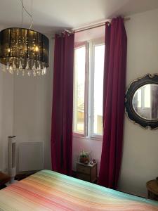 カンヌにある2 p Cannes - Suquet - centreのベッドルーム(紫色のカーテン、ベッド、鏡付)