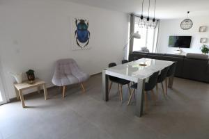 un soggiorno con tavolo e sedie bianchi di Gîte Le Scarabée a Saint Die