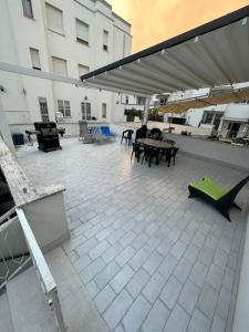 eine Terrasse mit Tischen, Stühlen und einer Markise auf einem Gebäude in der Unterkunft All'altezza del mare in Fossacesia