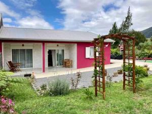 een roze en wit huis met een tuin bij La kaz 57 - Maison avec SPA privatif in La Plaine des Palmistes