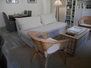 ein Wohnzimmer mit einem Sofa, einem Tisch und Stühlen in der Unterkunft Les Appartements de Cyrano in Bergerac