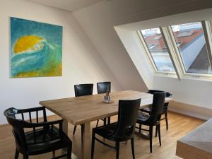 a dining room table with chairs and a painting on the wall at Rooftop Terrace- Panoramablick über Wien in Vienna