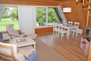 een eetkamer met een tafel, stoelen en ramen bij Zeltdachhaus mit W_LAN in Strandna in Damp