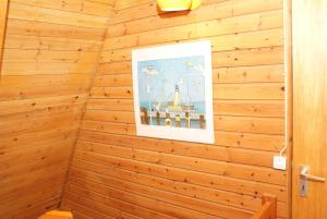 a corner of a wooden wall with a picture on it at Zeltdachhaus mit W_LAN in Strandna in Damp
