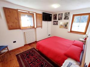 圣维托-迪卡多雷Casa Amabile的一间卧室设有红色的床和2个窗户。