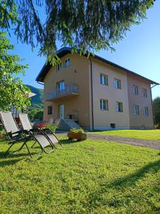 ein Haus mit zwei Gartenstühlen davor in der Unterkunft Guesthouse Nikolina in Korenica