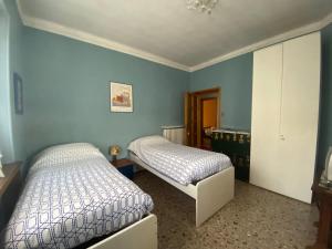 two beds in a bedroom with blue walls at Villa Ida in Collegno