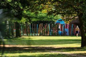 a man walking in front of a colorful playground at Les Gîtes du Domaine de Rhodes in Avignon