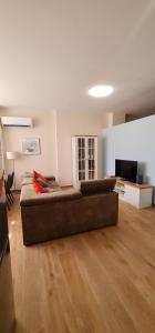 uma sala de estar com um sofá castanho num quarto em Family Vacation New House em Durrës