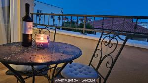 a table with a bottle of wine and a candle on a balcony at Casa Mili Jezera in Jezera