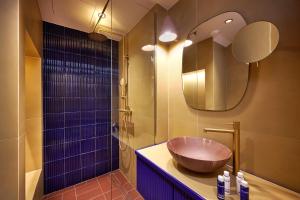 La salle de bains est pourvue d'un lavabo en bois et d'une douche. dans l'établissement LOOM ATHENS, à Athènes