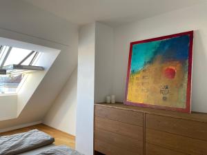 Schlafzimmer mit Wandgemälde und Kommode in der Unterkunft Rooftop Terrace- Panoramablick über Wien in Wien