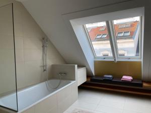 ein Bad mit einer Badewanne und einem Fenster in der Unterkunft Rooftop Terrace- Panoramablick über Wien in Wien