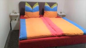 a bed with colorful sheets and pillows in a room at Ruegen_Fewo 24 in Thesenvitz