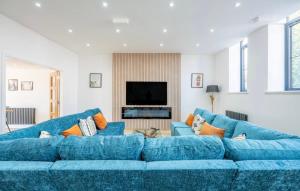 Sofá azul en la sala de estar con TV en The Old School Sleeps 14, en Lymington