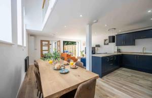 a kitchen and dining room with a wooden table at The Old School Sleeps 14 in Lymington